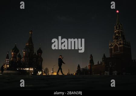 Moscou, Russie. 28 mars 2020. Un homme traverse la place Rouge avec des lumières étees lors de l'événement Earth Hour à Moscou, Russie, le 28 mars 2020. Crédit: Evgeny Sinitsyn/Xinhua/Alay Live News Banque D'Images