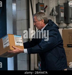 New York, NY - 28 mars 2020: Le maire Bill de Blasio aide à charger des boîtes de masques faciaux donnés par le secrétaire général de l'ONU Antonio Guterres et l'ambassadeur américain Kelly Craft au garage de l'ONU Banque D'Images