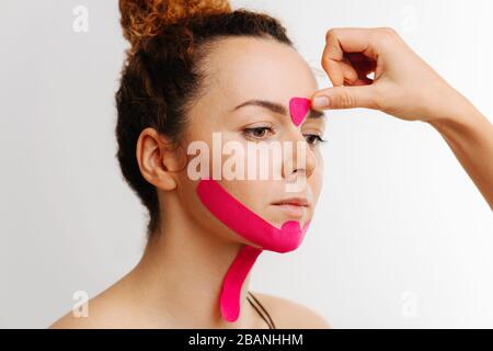 Gros plan portrait, coller au ruban cosmétique pour le visage Banque D'Images