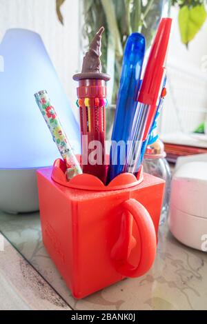 Un pot de stylos sur une table latérale. Banque D'Images