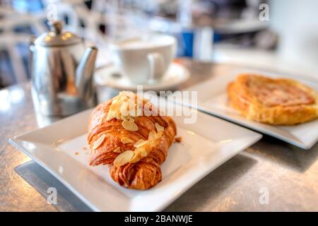 Petit-déjeuner pâte feuilletée aux croissants aux amandes avec tasse de café Latte. Banque D'Images