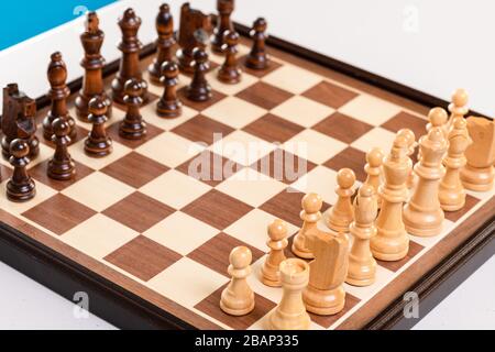 Planche à chessboard sur une table prête pour le jeu avec des chaises pour enfants sur l'arrière-plan. Banque D'Images