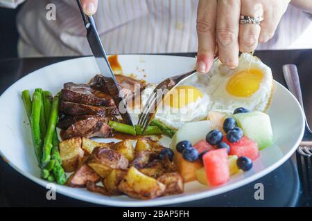 Miami Beach Florida,Eden,restaurant restaurants repas café cafés, plaque, plat, nourriture, pommes de terre, fruits, œufs, viande, asperges, femme femmes adulte adu Banque D'Images