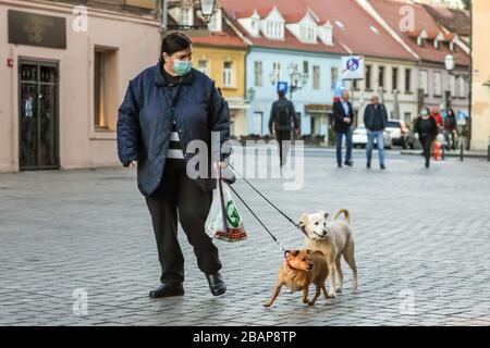 Zagreb, Croatie - 19 mars 2020 : les gens de la rue de Zagreb portent des masques de protection en raison de la crise du virus corona. Une femme sur la rue marche faire Banque D'Images