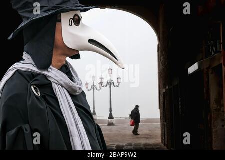 Médecin de peste contre les gondoles pendant la journée de brume à Venise, Italie, symbole de l'épidémie Banque D'Images