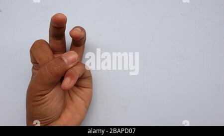 Main gauche photographiée avec la signification d'un symbole et fond blanc, pas dans la mise au point. Flou Banque D'Images