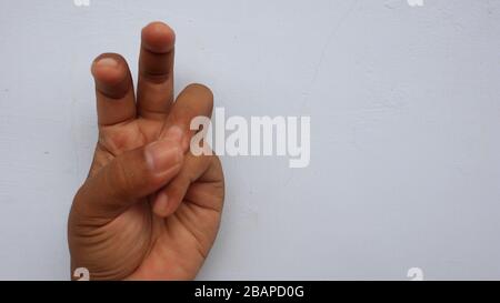 Main gauche photographiée avec la signification d'un symbole et fond blanc, pas dans la mise au point. Flou Banque D'Images