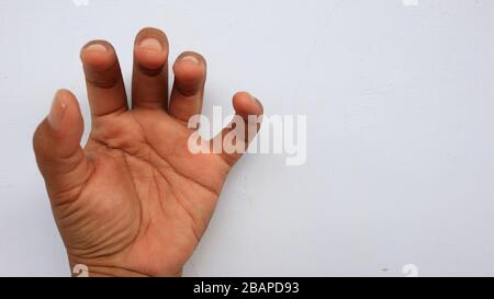 Main gauche photographiée avec la signification d'un symbole et fond blanc, pas dans la mise au point. Flou Banque D'Images