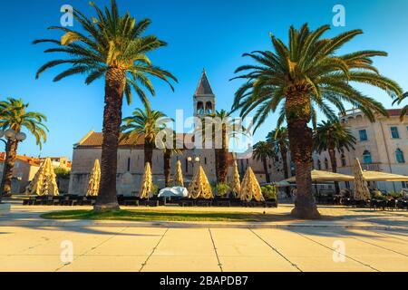 Cette jolie place de ville est bordée de palmiers et de charmants cafés près du port de Trogir, de la Dalmatie, de la Croatie et de l'Europe Banque D'Images