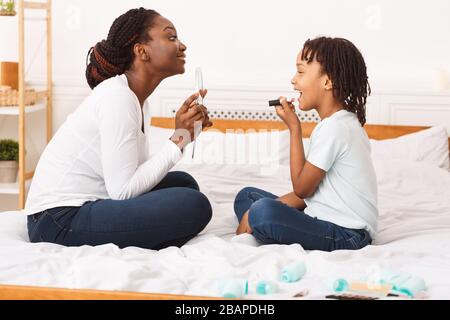 Petite fille afro faire le maquillage avec sa mère Banque D'Images