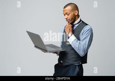 professionnel afro-américain homme d'affaires tenant ordinateur portable Banque D'Images