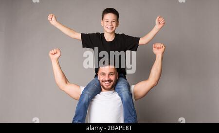 Papa excité tenant son fils sur les épaules, panorama Banque D'Images
