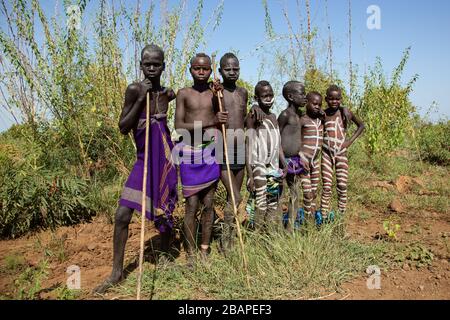 Morsi peint les garçons dans le Parc National de Mago, vallée de l'Omo d'Ethiopie Banque D'Images