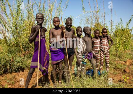 Morsi peint les garçons dans le Parc National de Mago, vallée de l'Omo d'Ethiopie Banque D'Images