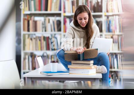 Jeune étudiante en études dans la bibliothèque Banque D'Images