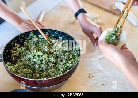 La famille chinoise fait des boulettes ensemble. Fabrication de boulettes maison à la maison. Banque D'Images