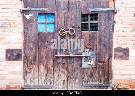 Ancienne porte double en bois avec de vieilles serrures et une poignée dans les rues de Bergame, en Italie Banque D'Images