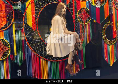 Femme mannequin assis et regardant dans la fenêtre d'une boutique de luxe. Vente Banque D'Images
