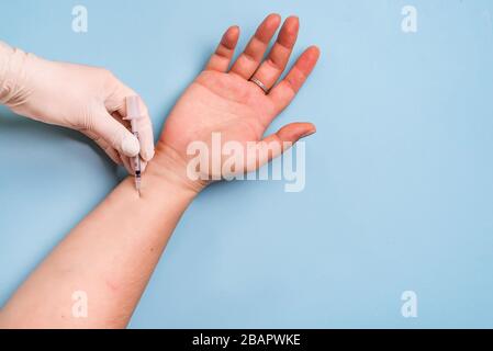 gros plan du médecin donnant une injection à une jeune femme sur un fond bleu, copier l'espace Banque D'Images