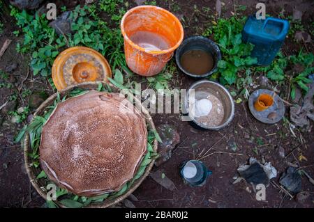 Femme cuisine Injera pancake comme du pain sur un mogogo au-dessus d'un feu. Lalibela, région d'Amhara, Ethiopie. Banque D'Images