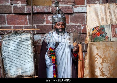 Portrait d'un prêtre orthodoxe éthiopienne tenant une croix dans l'église nakuto lab cave, région d'Amhara, Lalibela, Éthiopie Banque D'Images