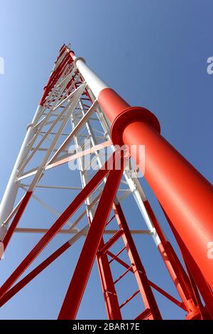 Cette photographie au niveau du sol représente la structure en acier complexe d'une tour de télécommunication, mettant en valeur sa construction robuste. Banque D'Images