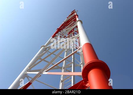 Cette photographie au niveau du sol représente la structure en acier complexe d'une tour de télécommunication, mettant en valeur sa construction robuste. Banque D'Images