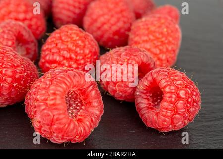 fruits rouges frais à la framboise sur plaque d'ardoise noire pour une mise au point sélective Banque D'Images
