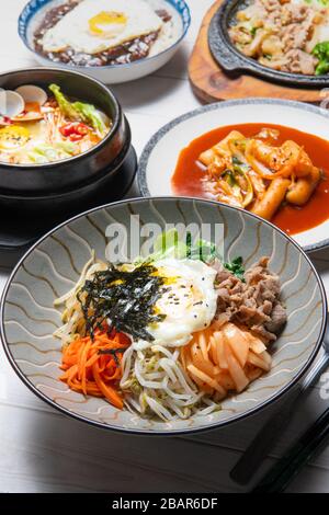 Bibimbap est servi comme un bol de riz blanc chaud recouvert de légumes ou kimchi et de pâte de piment et d'oeuf, de viande coupée en tranches Banque D'Images