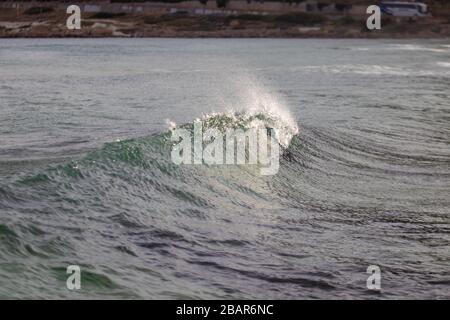 Une petite vague d'ondulation avec le soleil glistant au-dessus de l'océan Banque D'Images