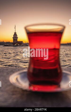 Thé turc traditionnel dans un verre avec la tour de Maiden à l'arrière-plan à Istanbul, en Turquie Banque D'Images