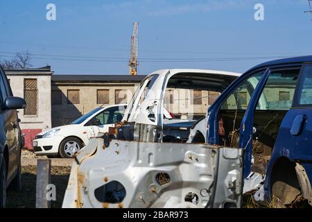 vieux cadre gris voiture démontée voiture avec des pièces rouillées dans la rue près de la clôture. Banque D'Images