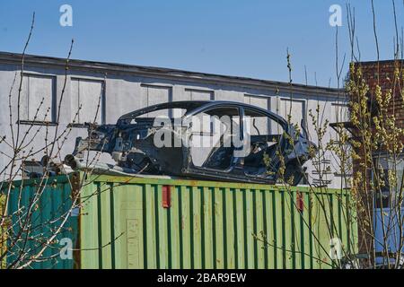 vieux cadre gris voiture démontée voiture avec des pièces rouillées dans la rue près de la clôture. Banque D'Images