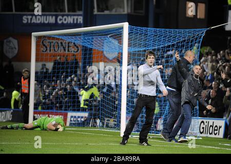 Les fans de Leeds United entrent dans le champ de jeu pour célébrer l'objectif de leur côté alors que Chris Kirkland, gardien de but de Sheffield Wednesday, s'est mis sur le terrain après avoir été frappé par un fan de Leeds Banque D'Images