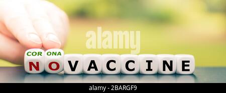 Symbole pour trouver un vaccin corona. La main transforme les dés et change l'expression 'pas de vaccin' en 'vaccin corona'. Banque D'Images