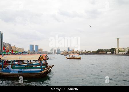 DUBAÏ, ÉMIRATS ARABES UNIS - 21 NOVEMBRE 2019 : Dubai creek avec abra, bateaux traditionnels et mouettes en journée nuageux Banque D'Images