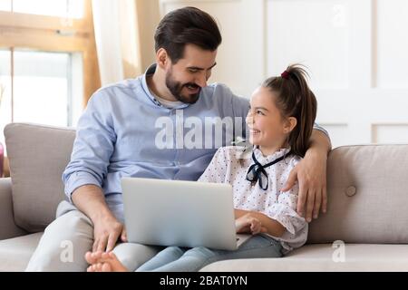 Un père souriant embrassant une petite fille, riant au film de comédie. Banque D'Images