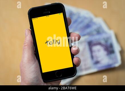 Une femme utilisant l'application Tally Accounting sur un téléphone mobile. (Usage éditorial uniquement) Banque D'Images