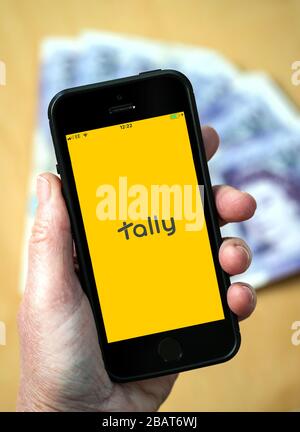 Une femme utilisant l'application Tally Accounting sur un téléphone mobile. (Usage éditorial uniquement) Banque D'Images