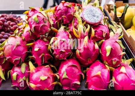 Le fruit du Dragon rouge, également connu sous le nom de Pitahaya, ou Pitaya, s'est enroulé en hauteur avec une tranche de moitié en exposition pour la vente dans un quartier chinois, stand de fruits, New York City Banque D'Images