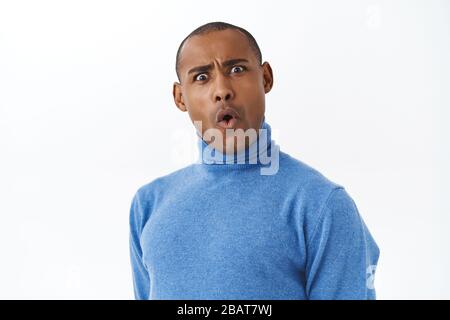 Vous dites quoi. Portrait en gros plan d'un homme adulte afro-américain mécontent et choqué, qui se replie sur les lèvres, fait un visage secoué étonnant, regardant avec Banque D'Images