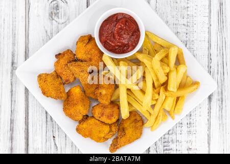 Table en bois vintage avec nuggets de poulet frais (gros plan; mise au point sélective) Banque D'Images