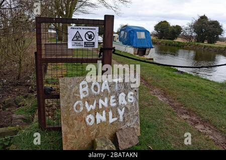 Le seul panneau fait maison du propriétaire du bateau à l'entrée des amarres de canal où les plaisanciers sont préoccupés par le fait que le chemin n'est pas assez large pour empêcher le contact social Banque D'Images