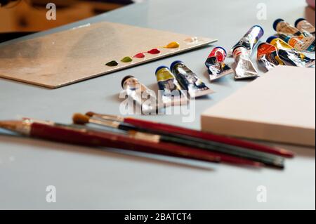 Table prête pour les arts et l'artisanat avec brosses et encres. Arrière-plan mise au point sur l'encre colorée sur la carte. Banque D'Images