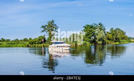 Bateau à moteur flottant sur la rivière ou le lac avec des roseaux et des tentatives de rivière verte, belle journée d'été sur la marina de bateaux Szczecin, Pologne Banque D'Images