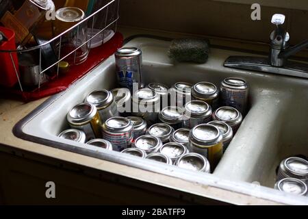 Videz les boîtes de bière dans un évier après une fête à Portland, Oregon, États-Unis Banque D'Images