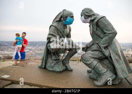 Pittsburgh, PA, États-Unis. 28 mars 2020. NOUVEAU en réponse au virus COVID-19 une personne intelligente a mis des masques sur le leader Seneca Guyasuta, à gauche et George Washington. La statue est appelée « points de vue ». Il donne sur la ville de Pittsburgh, PA. La ville est dans une commande de gouverneur Wolf « Stay at Home » depuis le 23 mars 2020. La statue marque l'extrémité la plus à l'ouest de He Grand View Scenic Byway, un officiel Pennsylvania Scenic Byway.UN père et une fille prennent une visite rapide du parc après avoir déposé de la nourriture à un parent. Crédit : Annie O'Neill/ZUMA Wire/Alay Live News Banque D'Images