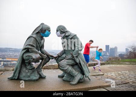 Pittsburgh, PA, États-Unis. 28 mars 2020. NOUVEAU en réponse au virus COVID-19 une personne intelligente a mis des masques sur le leader Seneca Guyasuta, à gauche et George Washington. La statue est appelée « points de vue ». Il donne sur la ville de Pittsburgh, PA. La ville est dans une commande de gouverneur Wolf « Stay at Home » depuis le 23 mars 2020. La statue marque l'extrémité la plus à l'ouest de He Grand View Scenic Byway, un Byway officiel de Pennsylvanie Scenic. Un père et une fille prennent une visite rapide du parc après avoir déposé de la nourriture à un parent. Crédit : Annie O'Neill/ZUMA Wire/Alay Live News Banque D'Images