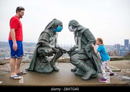 Pittsburgh, PA, États-Unis. 28 mars 2020. NOUVEAU en réponse au virus COVID-19 une personne intelligente a mis des masques sur le leader Seneca Guyasuta, à gauche et George Washington. La statue est appelée « points de vue ». Il donne sur la ville de Pittsburgh, PA. La ville est dans une commande de gouverneur Wolf « Stay at Home » depuis le 23 mars 2020. La statue marque l'extrémité la plus à l'ouest de He Grand View Scenic Byway, un officiel Pennsylvania Scenic Byway.UN père et une fille prennent une visite rapide du parc après avoir déposé de la nourriture à un parent. Crédit : Annie O'Neill/ZUMA Wire/Alay Live News Banque D'Images