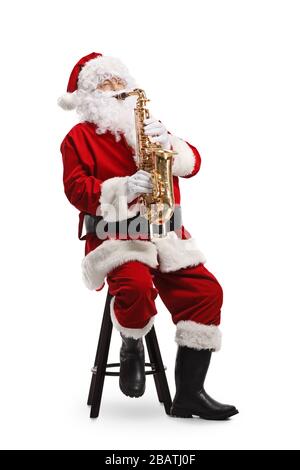 Père Noël assis sur une chaise et jouant un saxophone isolé sur fond blanc Banque D'Images